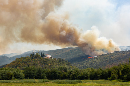 Helicopter against wildfire during strong wind and drought near Miren Castle in Sloveniaの写真素材