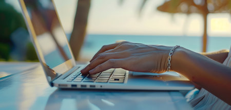 woman working on her laptop on vacation at the beach on a summer dayの素材