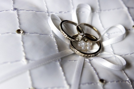 Wedding rings on white cushionの写真素材