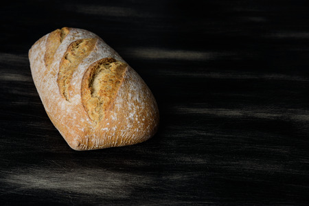 Loaf of bread on dark wooden backgroundの写真素材