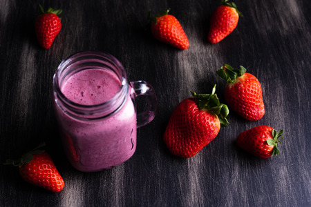 Strawberrie milkshake on dark wooden backgroundの写真素材
