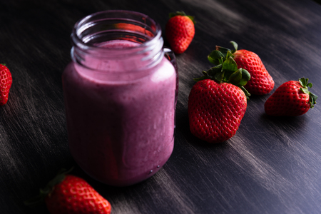 Strawberrie milkshake on dark wooden backgroundの写真素材