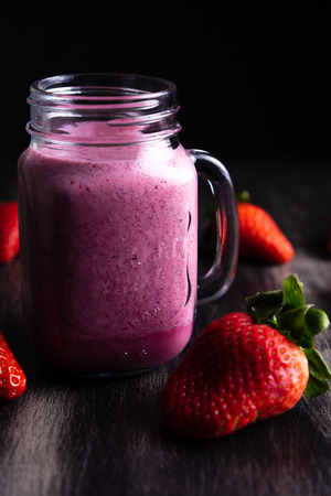 Strawberrie milkshake on dark wooden backgroundの写真素材