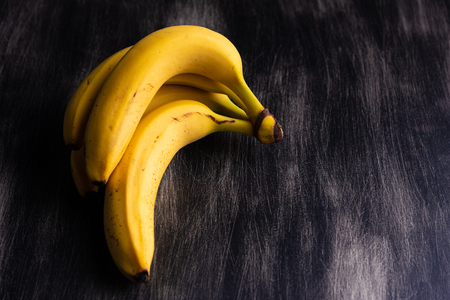 Bananas on dark wooden backgroundの写真素材