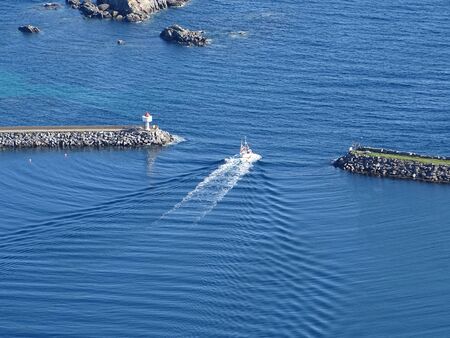 A fishing boat leaves the harbor.の写真素材