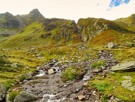 The Toma Lake in Switzerland is considered the source of the river Rhine, the first few kilometers it flows as a small stream down the rocks.の写真素材