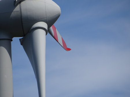 Close up of the hub of a wind turbine propeller looking towards blue sky.の写真素材