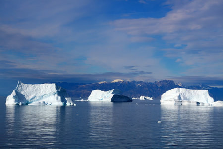 Icebergs in front of a mountain landscape in the Uummannaq Fjord, Greenland, Denmarkの写真素材
