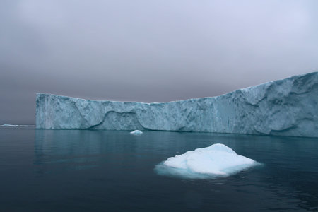 Iceberg in Ilulissat Icefjord with dramatic sky in Disko Bay, Greenland, Denmark