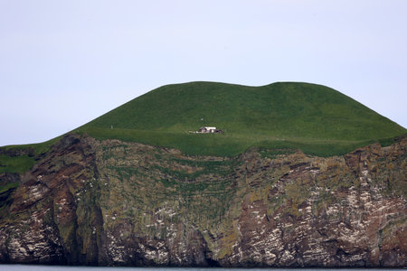Lonely house on the small offshore island of Bjarnarey-Vestmannaeyjar-Westman Islands-Icelandの写真素材