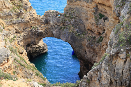 Rock arch at the coastal landscape of Ponta da Piedade near Lagos, Portugalの写真素材