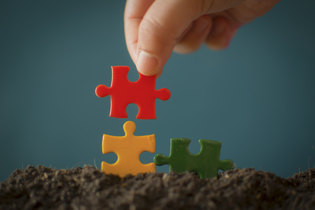 Closeup hand of man connecting jigsaw puzzle with sunlight effect, Business solutions, success and strategy conceptの写真素材