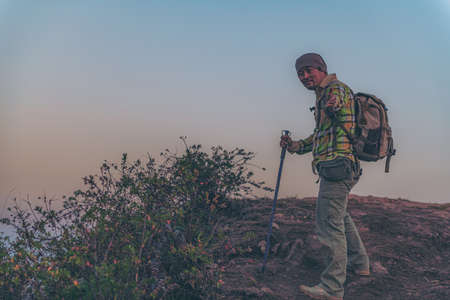Hikers walk up the mountain, take a break, and drink bottled water.の写真素材