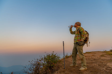 Hikers walk up the mountain, take a break, and drink bottled water.