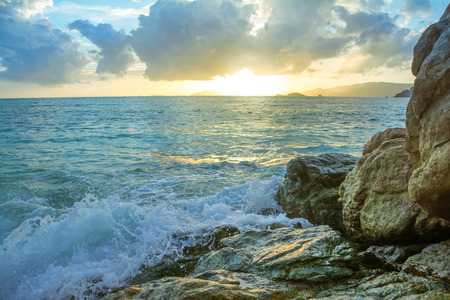 Splash waves hit rocks with the beautiful sunset and sky .の写真素材