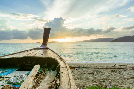 long tail old thai boat on the shore with sunlightの写真素材