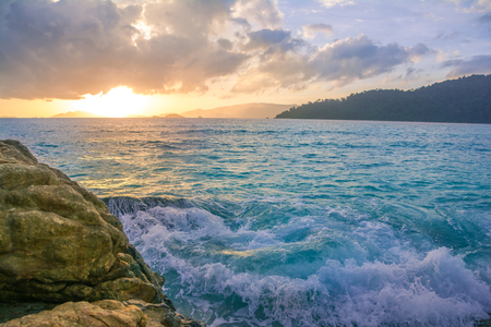 Splash waves hit rocks with the beautiful sunset and sky .の写真素材