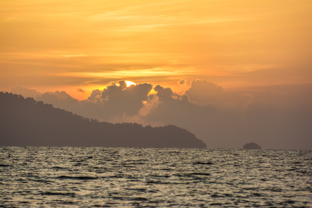 orange sunset behide the cloud over the seaの写真素材
