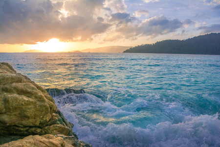 Splash waves hit rocks with the beautiful sunset and sky .の写真素材