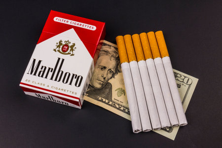 Indianapolis - Circa August 2016: Marlboro Cigarettes and Twenty Dollar Bills Representing the High Costs of Smoking. Marlboro is a product of the Altria Group Xのeditorial素材
