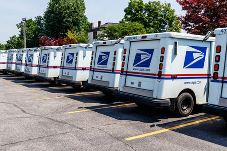 Logansport - Circa June 2018: USPS Post Office Mail Trucks. The Post Office is Responsible for...