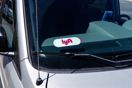 Indianapolis - Circa April 2019: Car for hire with a Lyft sticker and cell phone. Lyft and Uber have...