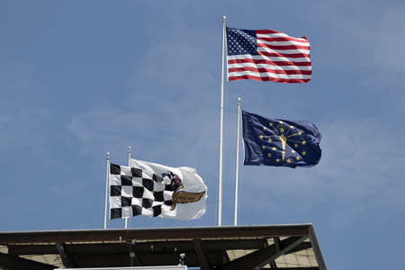 Indianapolis - Circa May 2022: American Flag, Indiana State Flag, Checkered Flag and the Flag of Indianapolis Motor Speedway atop the IMS Pagoda.のeditorial素材