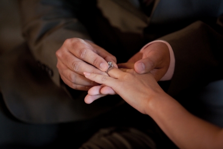 putting a wedding ring on the bride fingerの写真素材