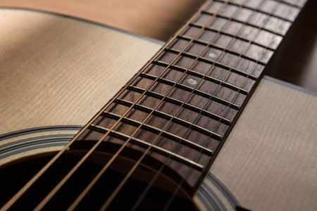 part of guitar sound hole with string on blurred wood background light and shadow filter toneの写真素材