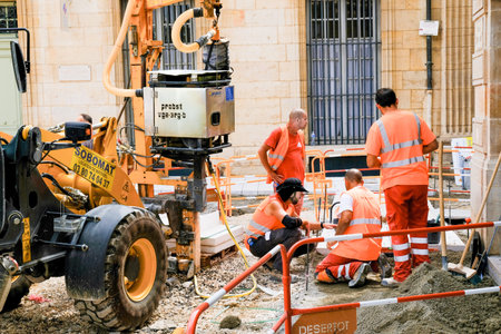 TOULOUSE, FRANCE - AUGUST 10, 2018 - Street workers in orange uniforms are discussing upcoming pavement repairs.のeditorial素材