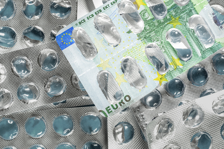 Empty blister pack of pills with 100 euro bill picture. Medical concept of expensive treatment of diseases in Europe.の写真素材