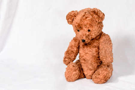 Sad Teddy Bear on white background: old brown toy from last century.の写真素材
