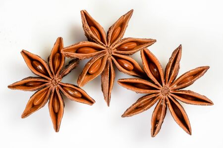 Star anise. Three star anise fruits. Macro close up Isolated on white background with shadow, top view of chinese badiane spice or Illicium verum.の写真素材
