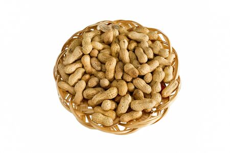 Peanuts. Dry whole nuts on bamboo plate, isolated on white background without shadow.の写真素材