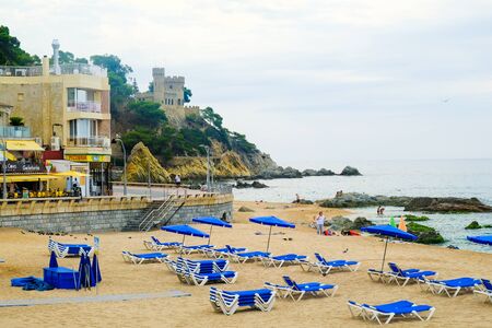 LLORET DE MAR, SPAIN - JULY 28, 2019: Empty beach on an early cloudy morning in Costa Brava. Concept of rest. Summer travel.のeditorial素材
