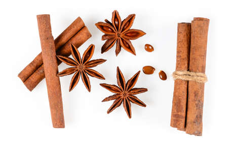 Cinnamon sticks and three anise star spice with seeds. Close-up macro isolated on white background with light shadow. Top view, flat lay,の写真素材