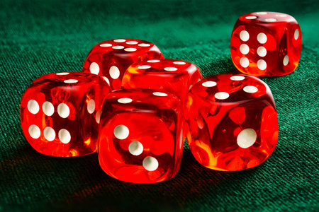 Six red acrylic transparent dices for games. Gambling translucent dices on dark-green velvet...