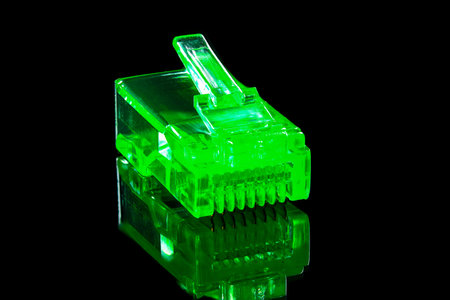 Connector rj-45. Neon green transparent connector rj45 for network and internet. Close up macro on...