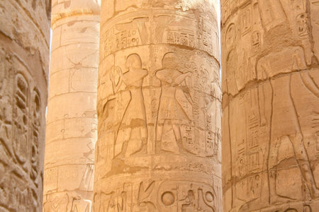 Karnak temple complex in Luxor, Egypt. Ancient bas relief with hieroglyphs on columns, pharaoh and...