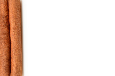 White background with cinnamon stick on left side. Close-up macro isolated on white background with...