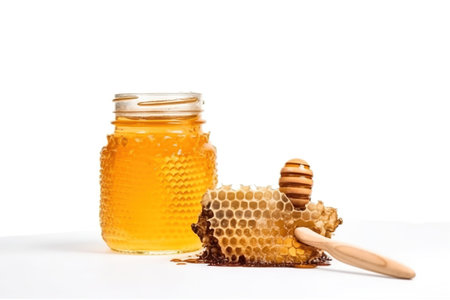 Honeycombs and wooden honey dipper isolated on white backgroundの素材