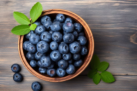 Fresh blueberries in bowl on wooden background. Top view with copy spaceの素材