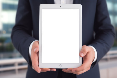 Businessman holding a tablet pc with white screen in his hands.の素材