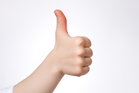 Female hand showing thumbs up sign on white background. Isolated.の素材