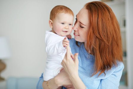 Pretty woman holding a smiling newborn baby