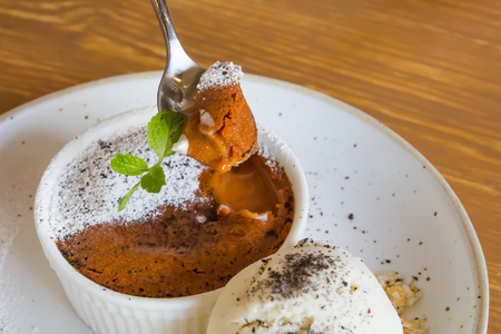 Spoon scoop thai tea cake Lava brown color and ice cream are next to it.の写真素材