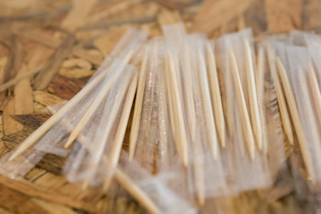 Toothpicks in plastic wrap on the wood table.