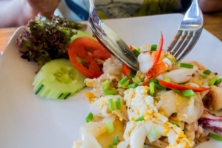Fried noodle with sea food on a white plate.の写真素材