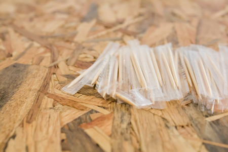 Toothpicks in plastic wrap on the wood table.の写真素材
