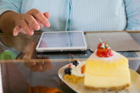 People are watching tablet in a cake shop.の写真素材